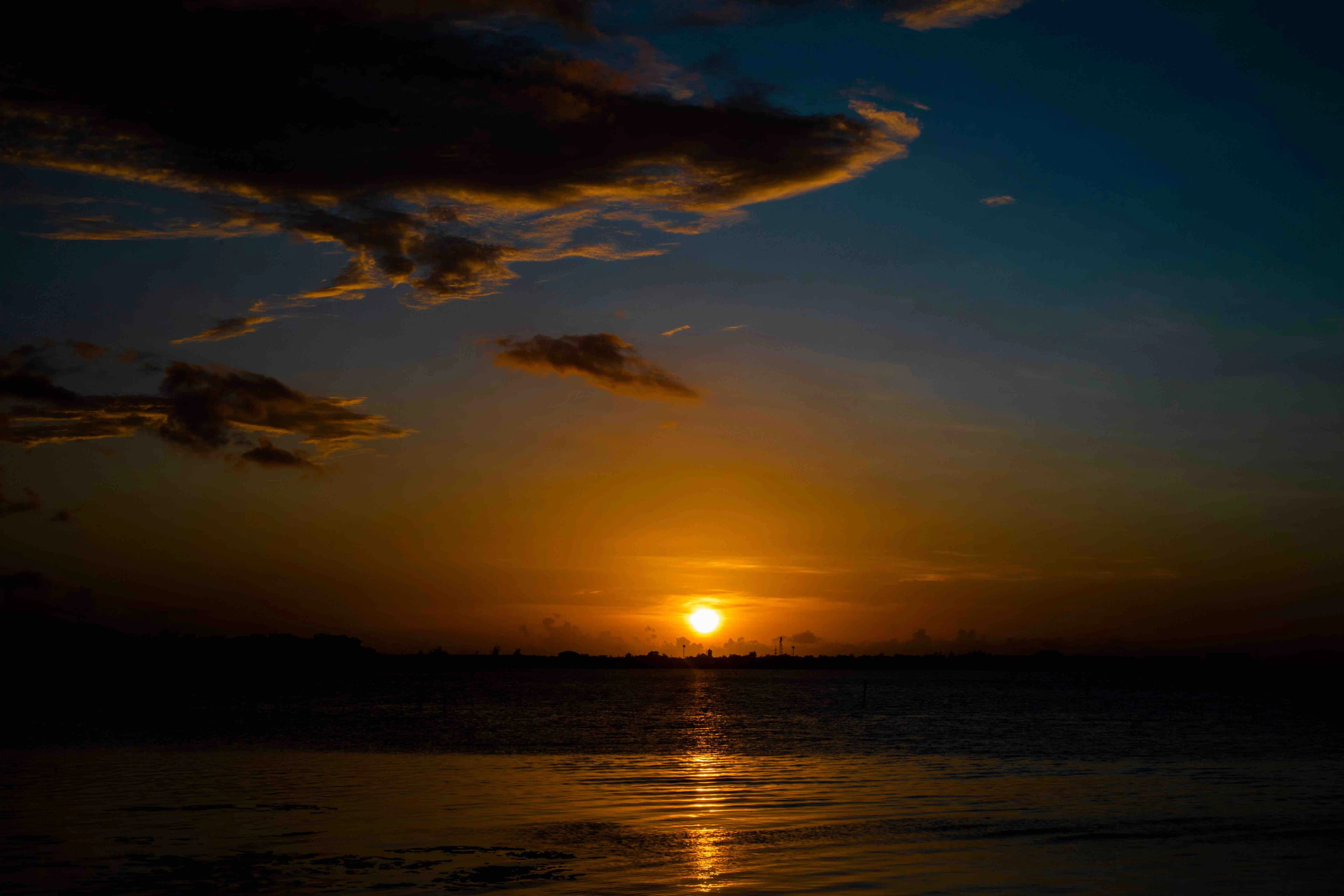 The sun setting over the water on a boat cruise